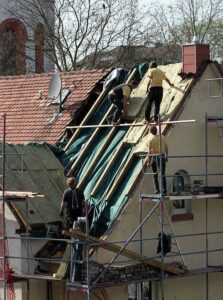 Zimmermänner bringen eine Zwischensparrendämmung an, im Rahmen einer Dachsanierung.