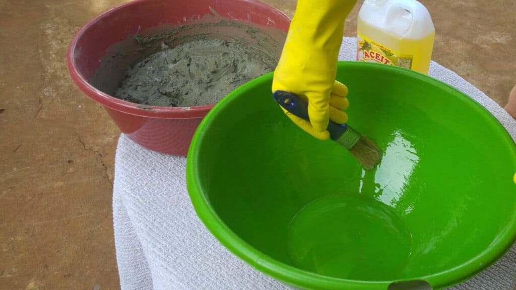 Mit dem Pinsel verstreichen. Mindestens bis auf die Höhe an die der Beton nachher reichen wird.